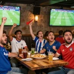 Cakhiatv football fans in a lively sports bar cheering during a live match.